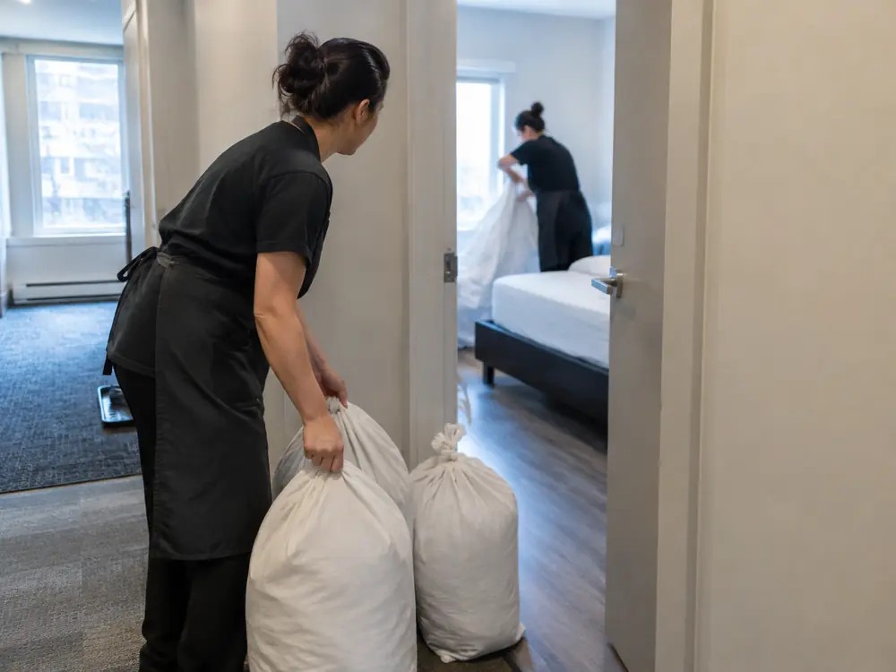 A cleaner preparing laundry after a guest checkout