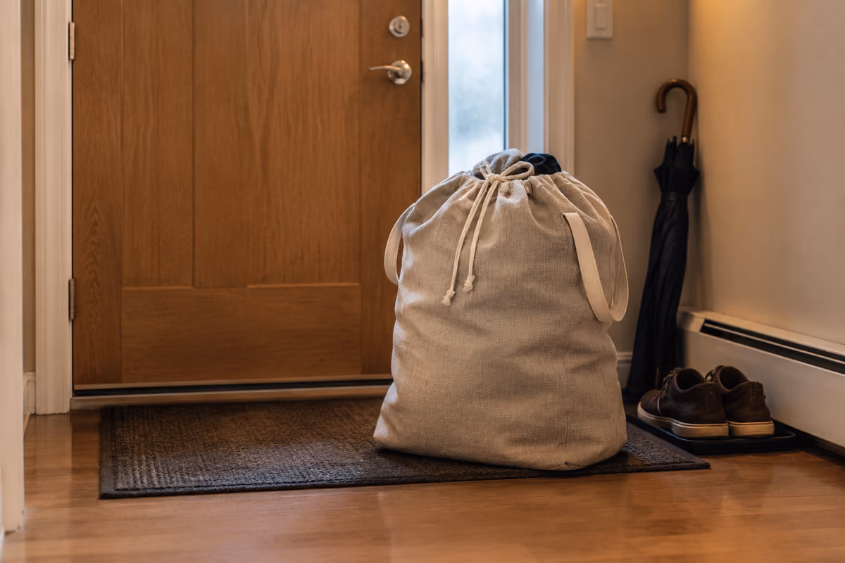 Two laundry baskets filled with clothes near a wooden interior door