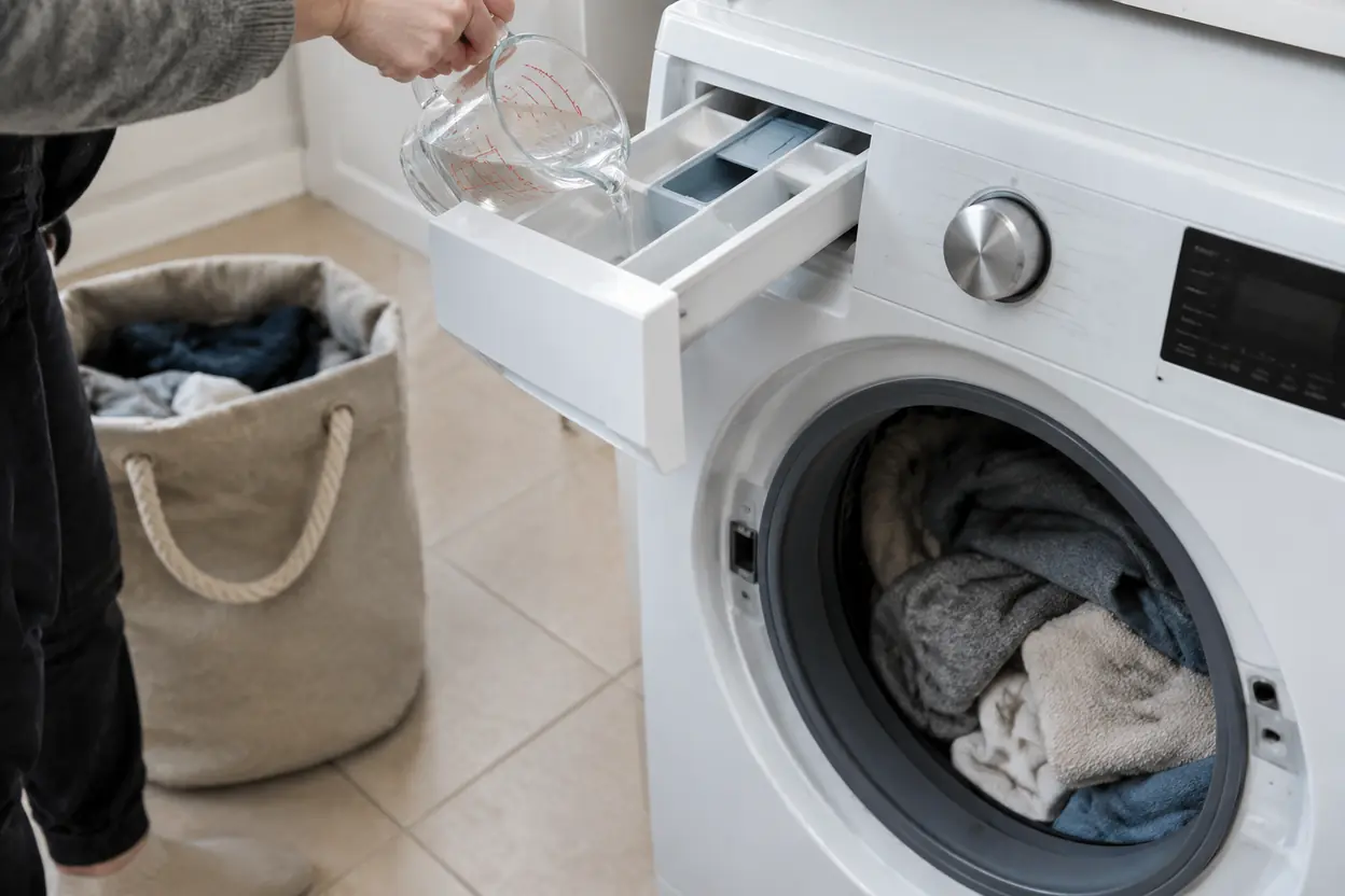 A home laundry counter with a washing machine and measured detergent.